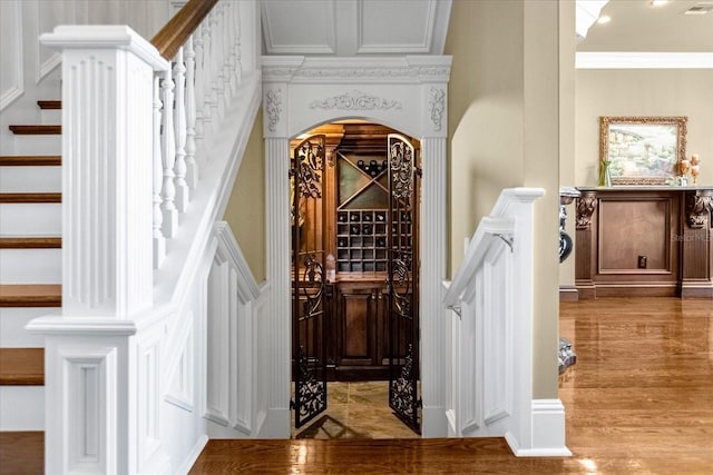 interior space featuring arched walkways, crown molding, and wood finished floors