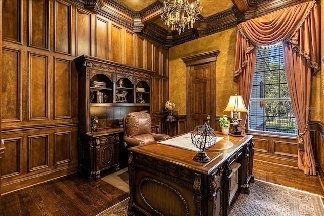 home office featuring dark wood finished floors, a decorative wall, ornamental molding, wainscoting, and a chandelier