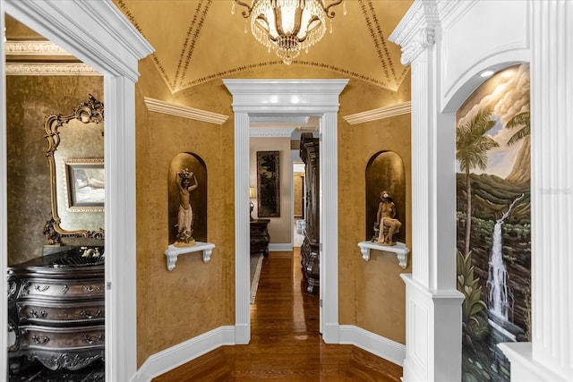 hallway featuring lofted ceiling, dark wood-style flooring, baseboards, and an inviting chandelier