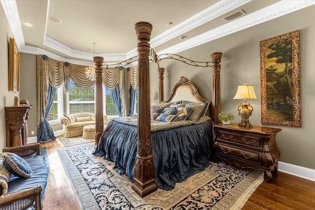 bedroom featuring visible vents, crown molding, and wood finished floors