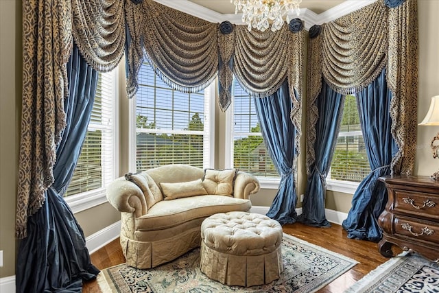 sitting room featuring crown molding, a notable chandelier, baseboards, and wood finished floors