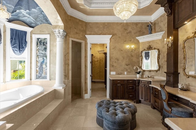 bathroom featuring decorative columns, a bath, ornamental molding, vanity, and a notable chandelier