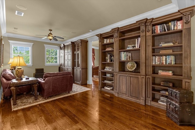 living area featuring ceiling fan, dark wood-type flooring, visible vents, and crown molding