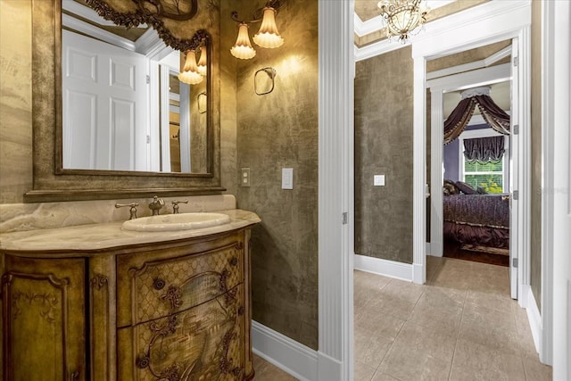 ensuite bathroom featuring crown molding, vanity, a chandelier, baseboards, and tile patterned floors