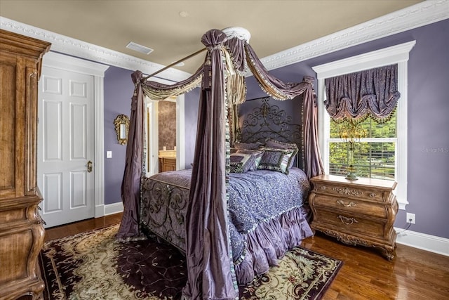 bedroom featuring crown molding, baseboards, and wood finished floors