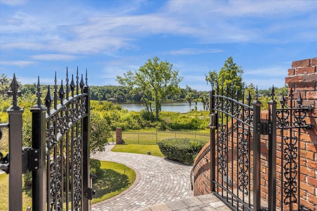 view of gate featuring a water view and fence