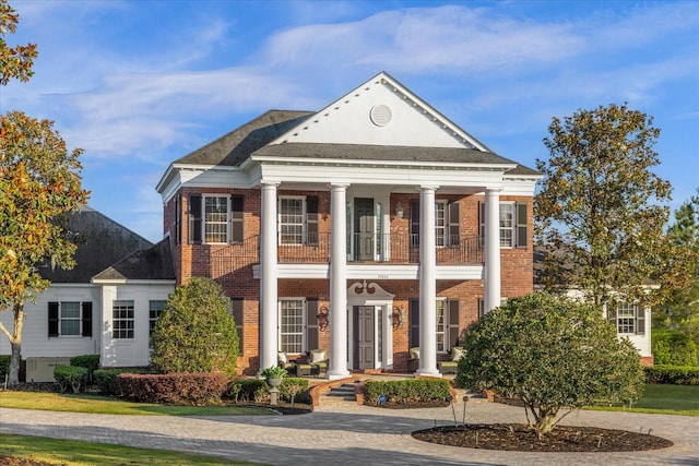 view of front of home with brick siding and a balcony