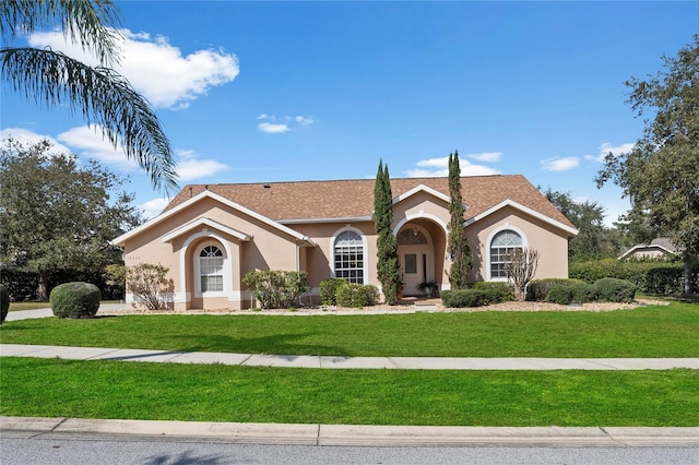 mediterranean / spanish home with a front yard and stucco siding