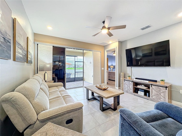 living room featuring light tile patterned floors, visible vents, and a ceiling fan