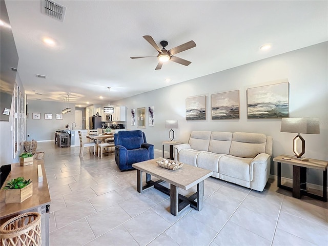 living room featuring light tile patterned floors, ceiling fan, and visible vents