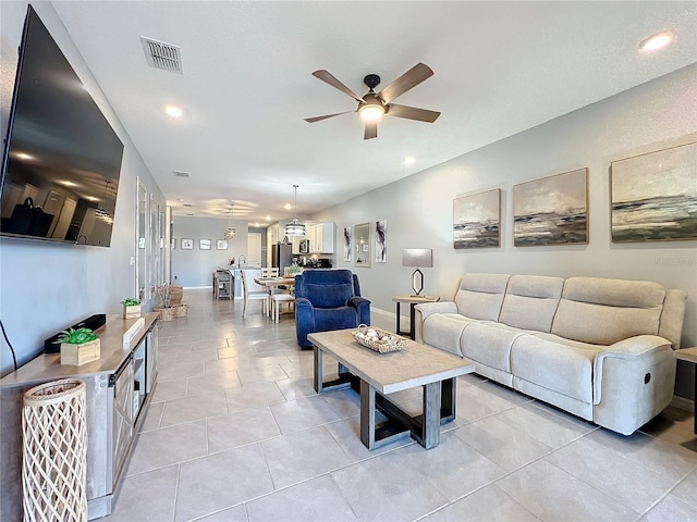 living room featuring light tile patterned floors, baseboards, visible vents, a ceiling fan, and recessed lighting