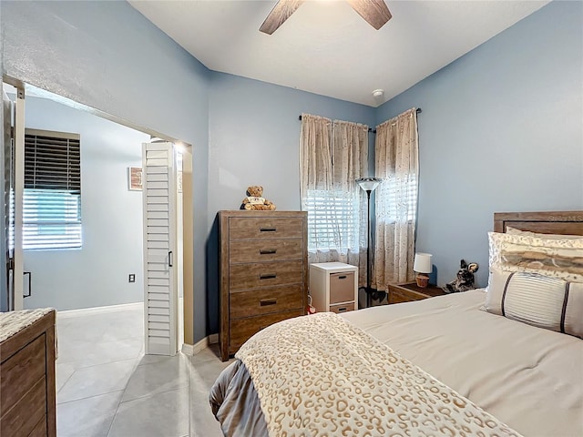 bedroom featuring ceiling fan, light tile patterned floors, and baseboards