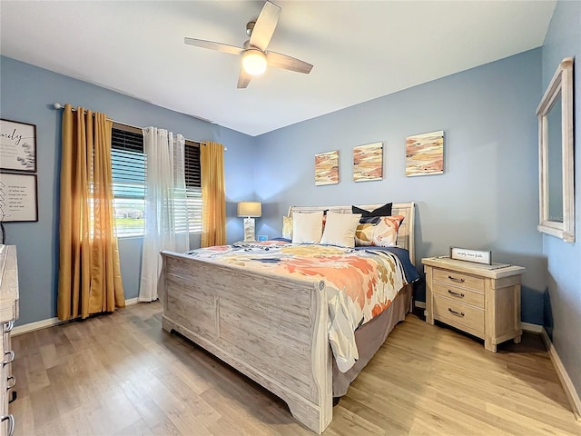 bedroom with light wood finished floors, baseboards, and a ceiling fan