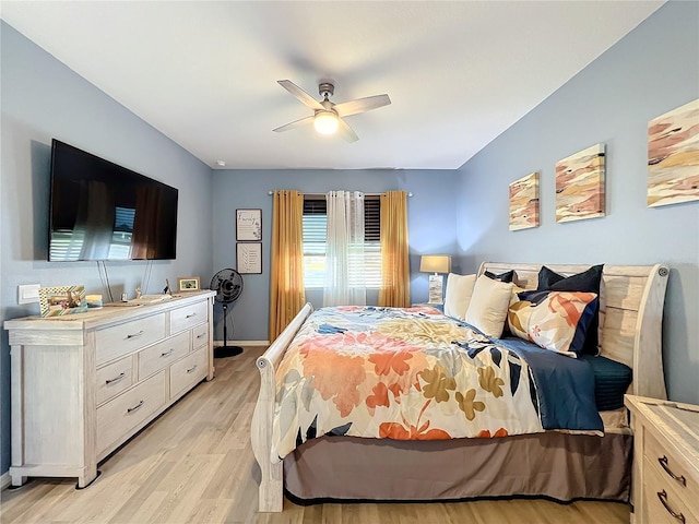 bedroom featuring ceiling fan, light wood-style flooring, and baseboards