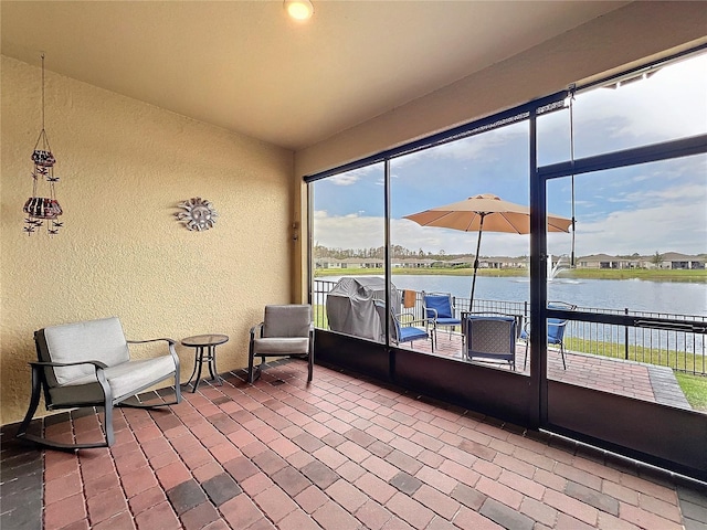 sunroom featuring a water view