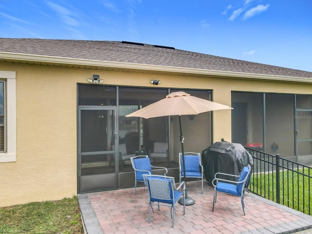 view of patio featuring a sunroom, fence, and grilling area