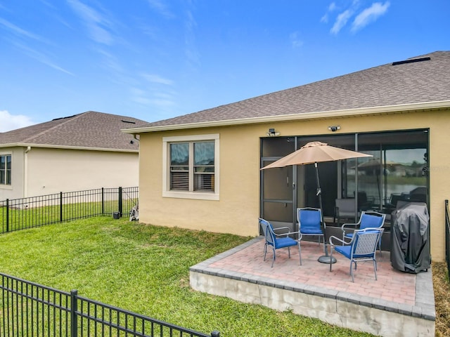 back of house with stucco siding, a shingled roof, a lawn, a patio area, and fence