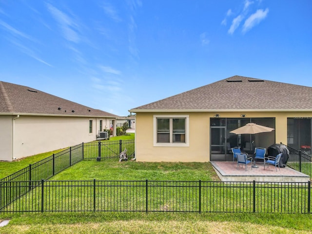 back of house featuring a fenced backyard, roof with shingles, a lawn, stucco siding, and a patio area