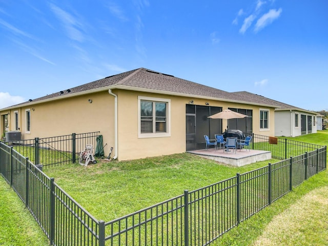 rear view of property featuring a patio area, fence, a lawn, and stucco siding