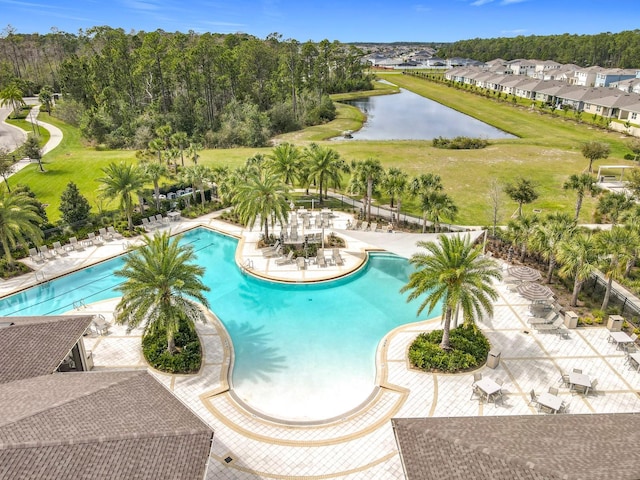 community pool featuring a patio area, a water view, and fence