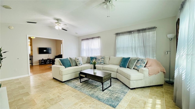 living area featuring a ceiling fan, visible vents, vaulted ceiling, and baseboards