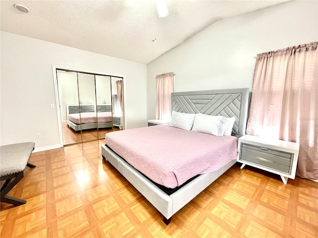 bedroom with lofted ceiling, a textured ceiling, a closet, and baseboards