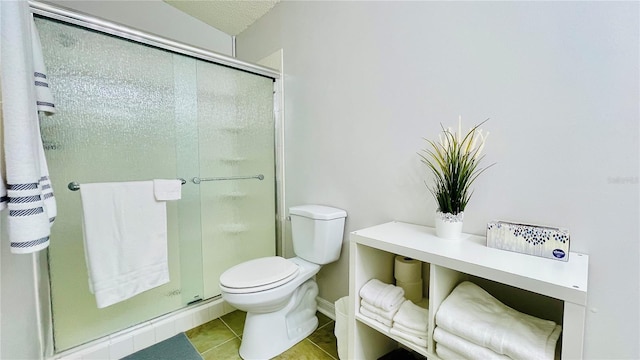 full bathroom with toilet, a stall shower, and tile patterned flooring