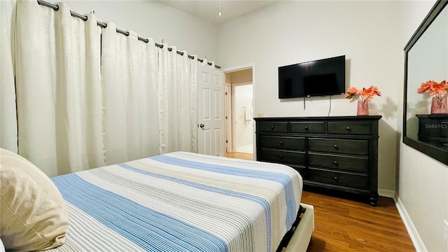 bedroom featuring baseboards and wood finished floors