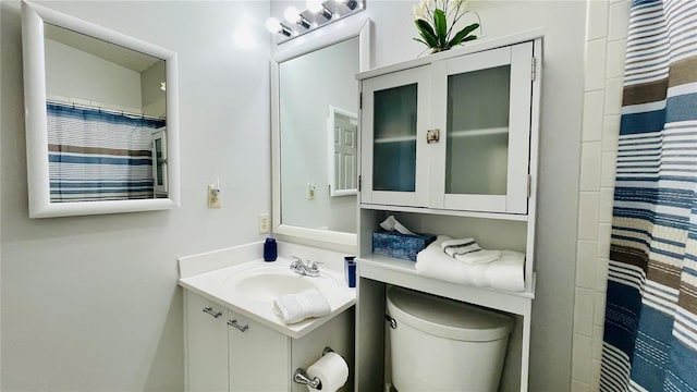 full bathroom featuring toilet, a shower with shower curtain, and vanity