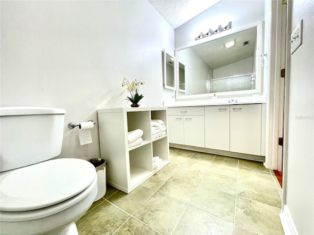 full bathroom with a textured ceiling, toilet, vanity, baseboards, and tile patterned floors