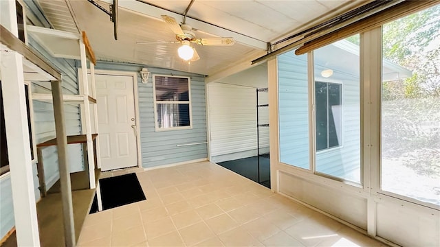 unfurnished sunroom with lofted ceiling and a ceiling fan