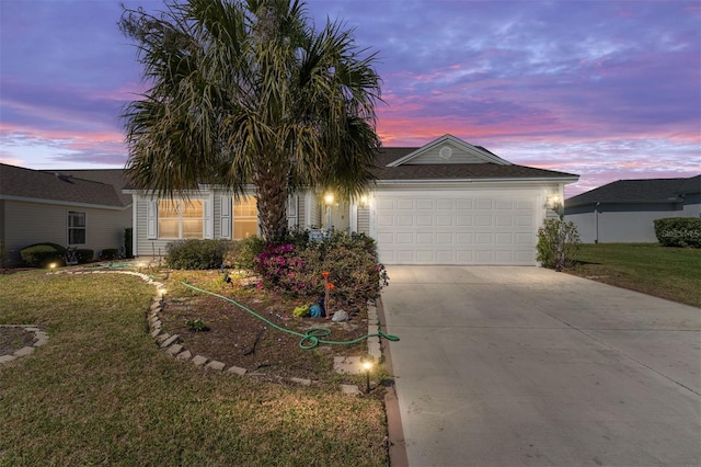 view of front of house featuring concrete driveway, a yard, and an attached garage