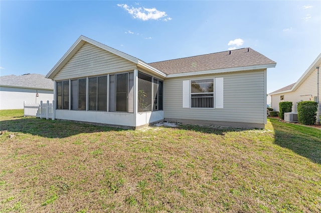 rear view of property with a yard, central AC, and a sunroom