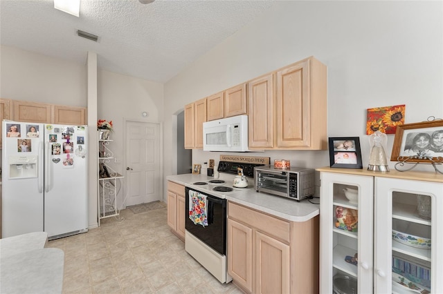 kitchen with a toaster, white appliances, visible vents, light countertops, and light brown cabinetry