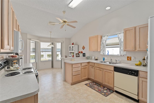 kitchen with light brown cabinets, a peninsula, white appliances, and a sink