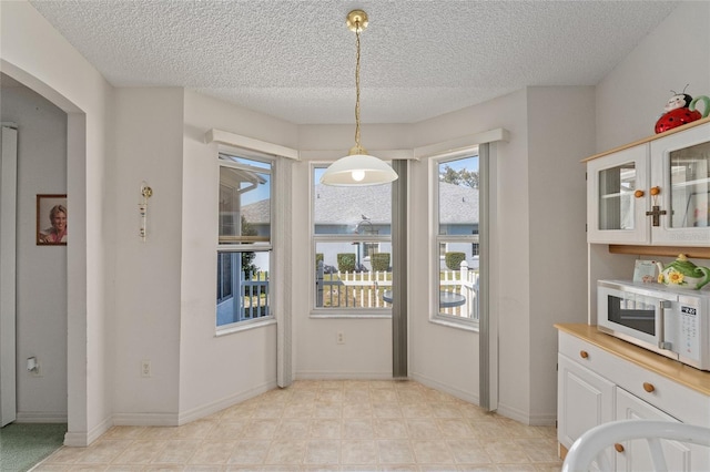 dining area with a textured ceiling and baseboards