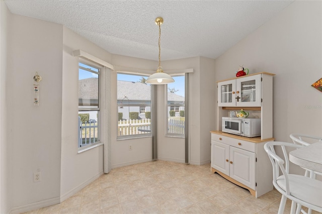 dining room with a textured ceiling and baseboards