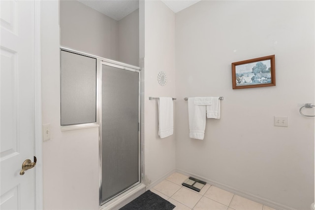 full bathroom featuring a stall shower, baseboards, and tile patterned floors