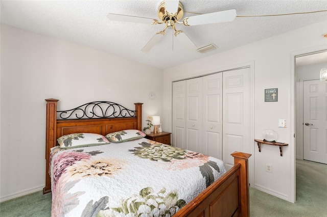 bedroom with ceiling fan, a textured ceiling, a closet, and light colored carpet