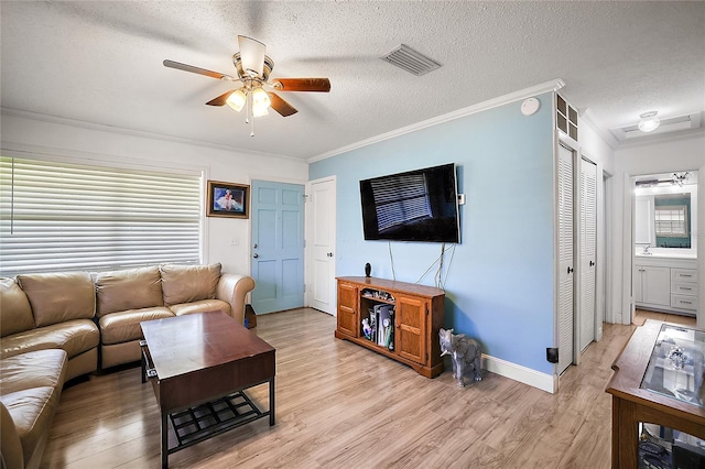 living area featuring crown molding, visible vents, ceiling fan, and light wood finished floors