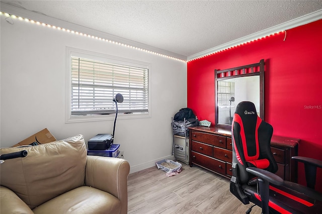 office space featuring ornamental molding, baseboards, a textured ceiling, and light wood finished floors