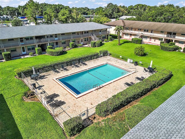 pool featuring a residential view, fence, and a lawn