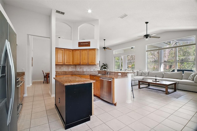 kitchen featuring a peninsula, stainless steel appliances, visible vents, and open floor plan