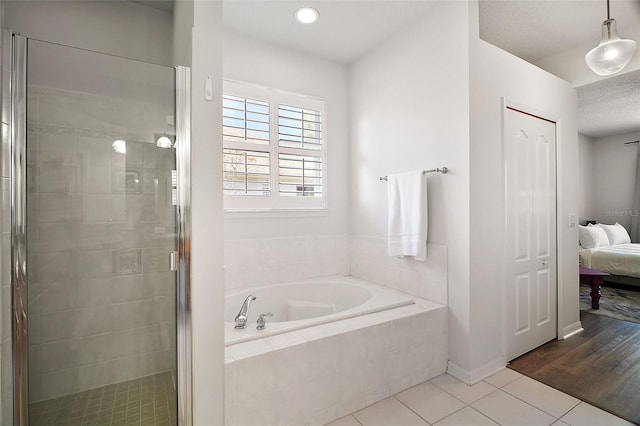 ensuite bathroom with tile patterned floors, a garden tub, ensuite bathroom, and a shower stall