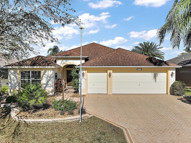 view of front facade with driveway, an attached garage, and stucco siding