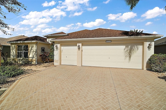 ranch-style house with an attached garage, concrete driveway, and stucco siding