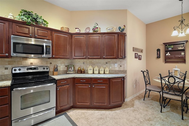 kitchen featuring stainless steel appliances, hanging light fixtures, light stone countertops, and decorative backsplash