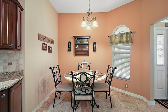 dining space featuring a chandelier and baseboards