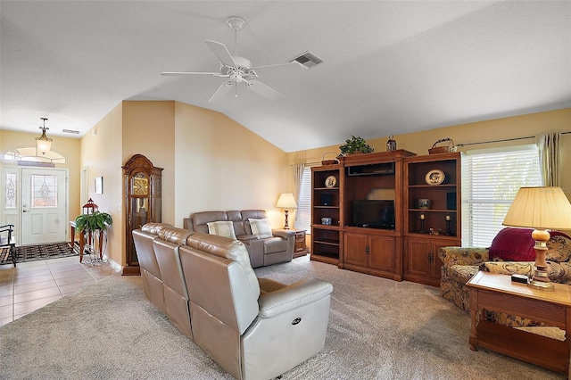 tiled living area featuring carpet floors, ceiling fan, visible vents, and vaulted ceiling