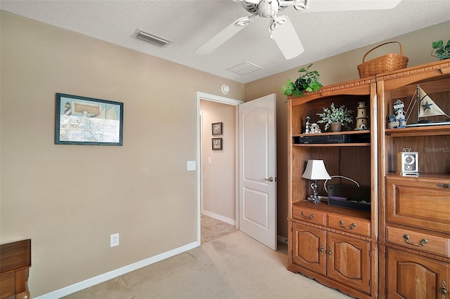 interior space featuring baseboards, visible vents, a textured ceiling, and light colored carpet